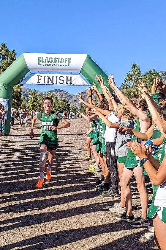 Racers running through the custom inflatable arch at Flagstaff High School